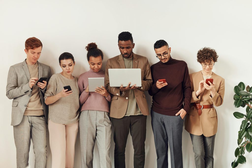 Employees all standing in a line looking at their devices